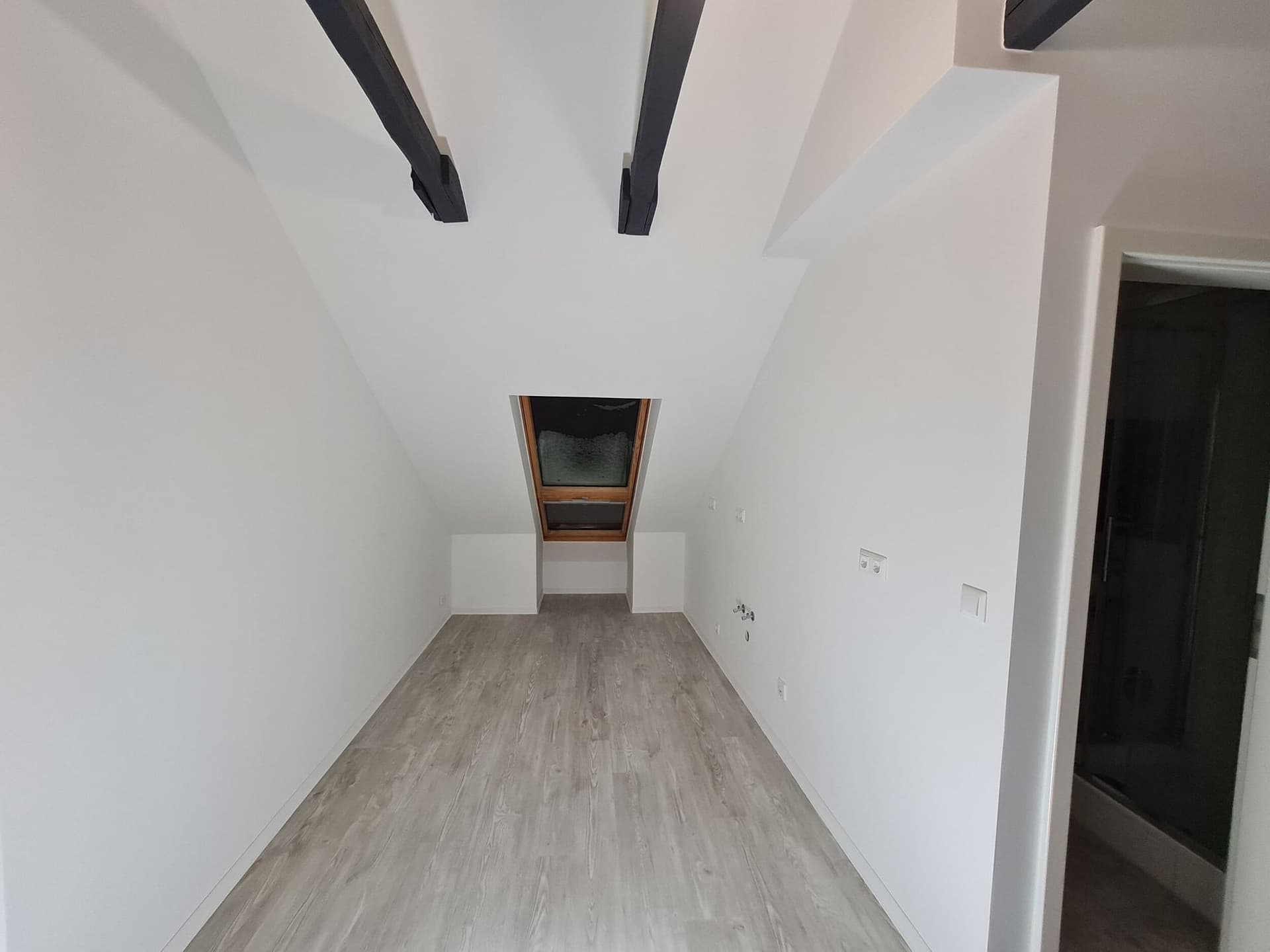 Zimmer unter der Dachschräge mit Holzbalken