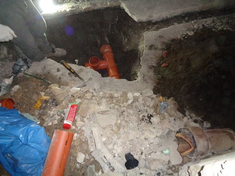 Freigelegte Abwasserleitung im Erdreich