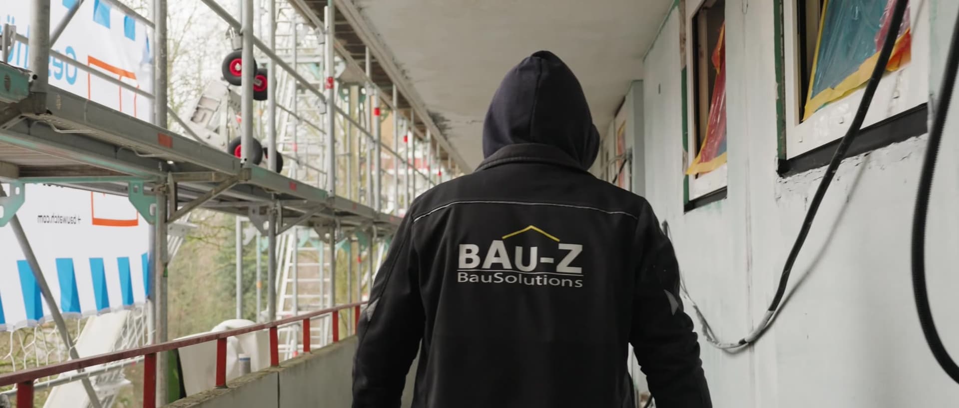 Zwei Handwerker arbeiten auf Leitern an der Zimmerdecke